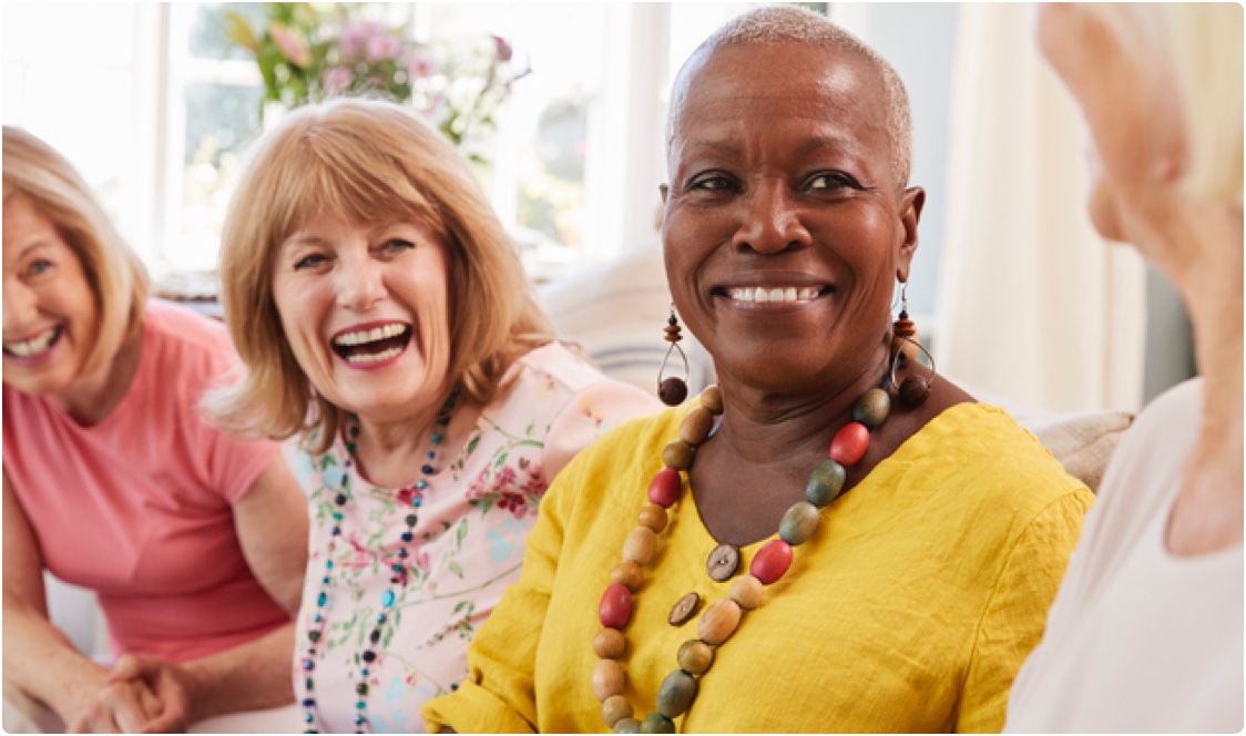 Group of people sitting on a couch and talking.